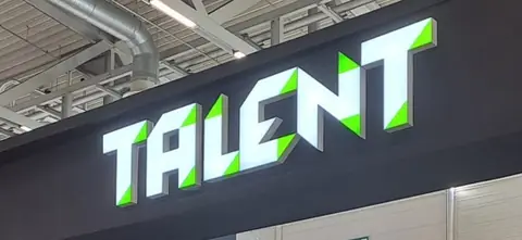 Podświetlane litery LED TALENT na ciemnej elewacji