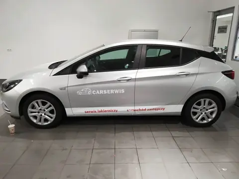 Srebrny Opel Astra z oklejeniem CarSerwis na drzwiach i błotniku