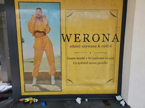 Witryna sklepu Werona oklejona grafiką z modelką i nazwą sklepu