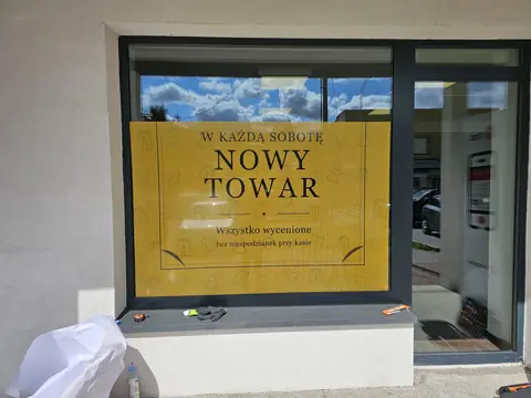 Witryna Werona oklejona grafiką z hasłem W każdą sobotę nowy towar