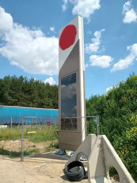 Pylon reklamowy przy stacji paliw w trakcie montażu